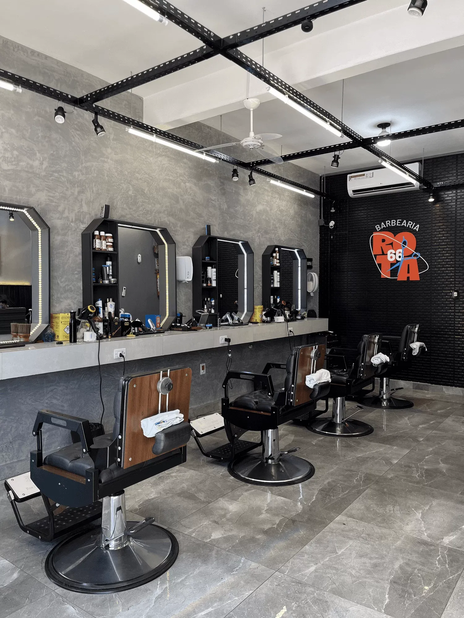 Barbearia com cadeiras pretas e identidade visual própria